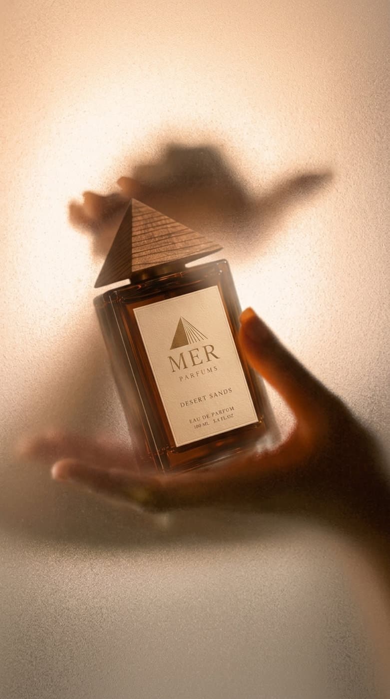 A hand holding a bottle of Desert Sands